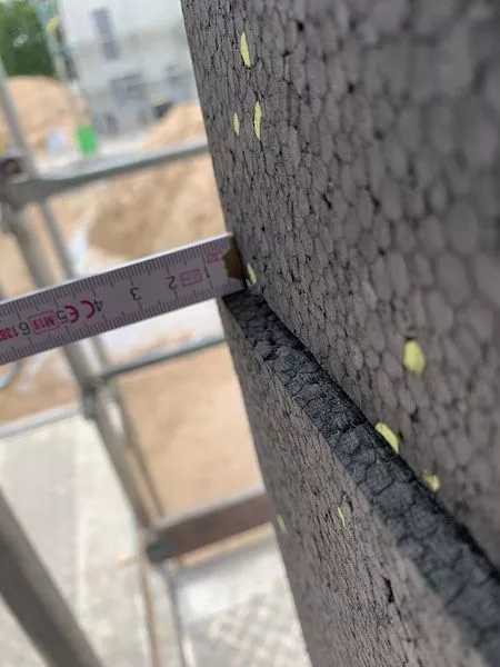 Ein Zollstock mit dem die Wand gemessen wird